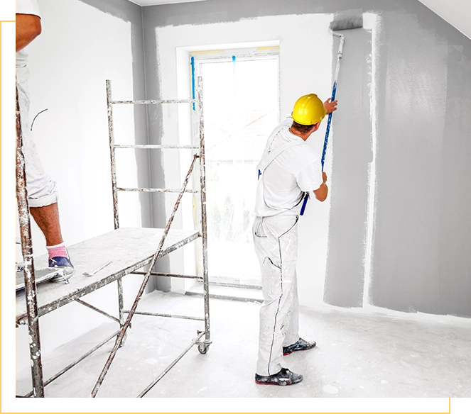 Two men are painting a room white.