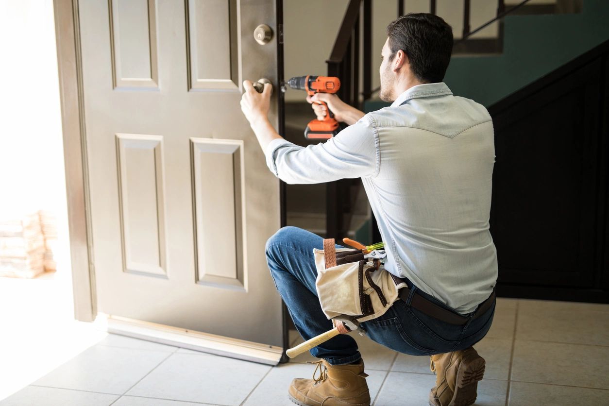 A man is fixing the door of his house